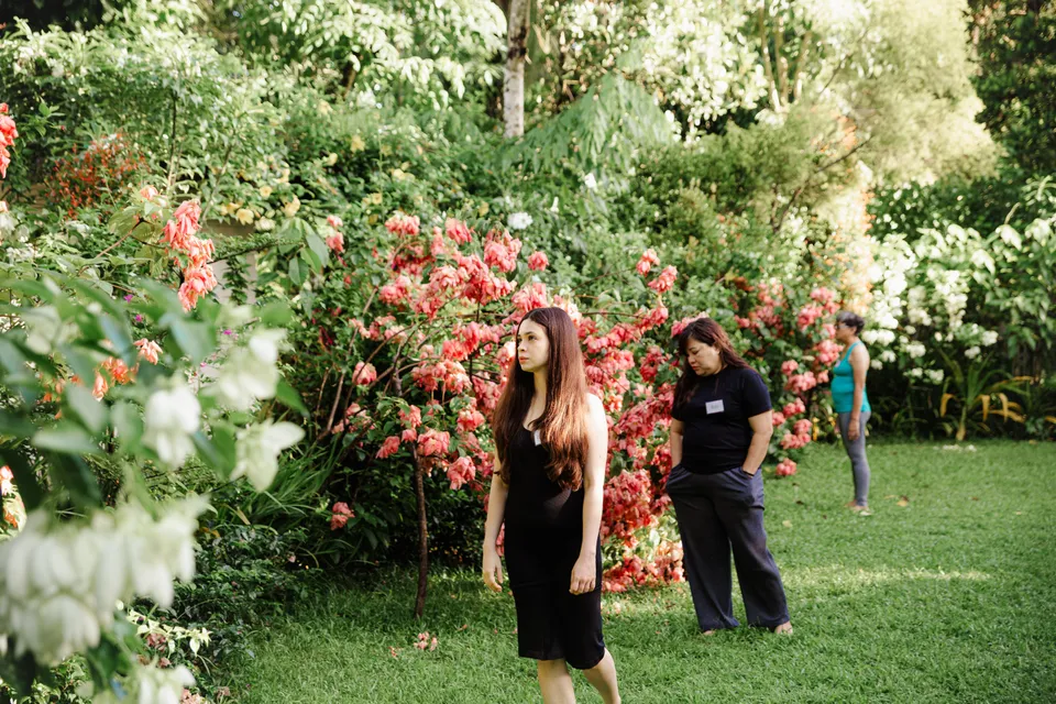 Guests walking through the Tallaro garden by pink bougainvillea