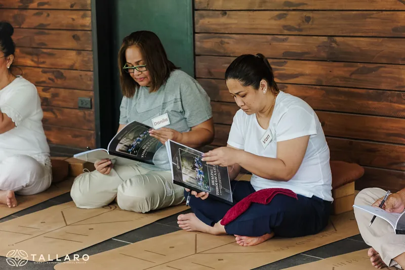 Women reading workbooks together during a retreat workshop