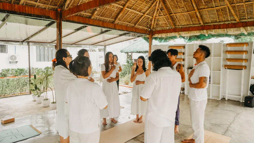 Retreat guests in white gathered under the pavilion