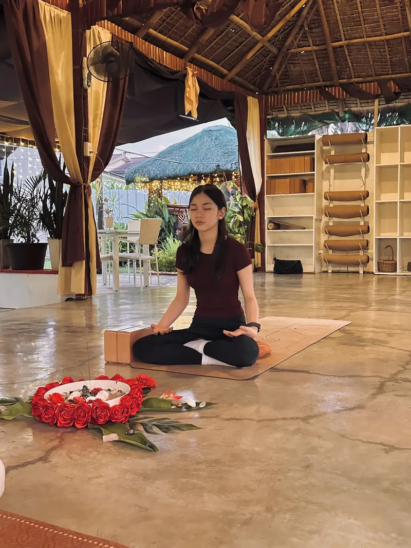 A teen meditating on the pavilion floor