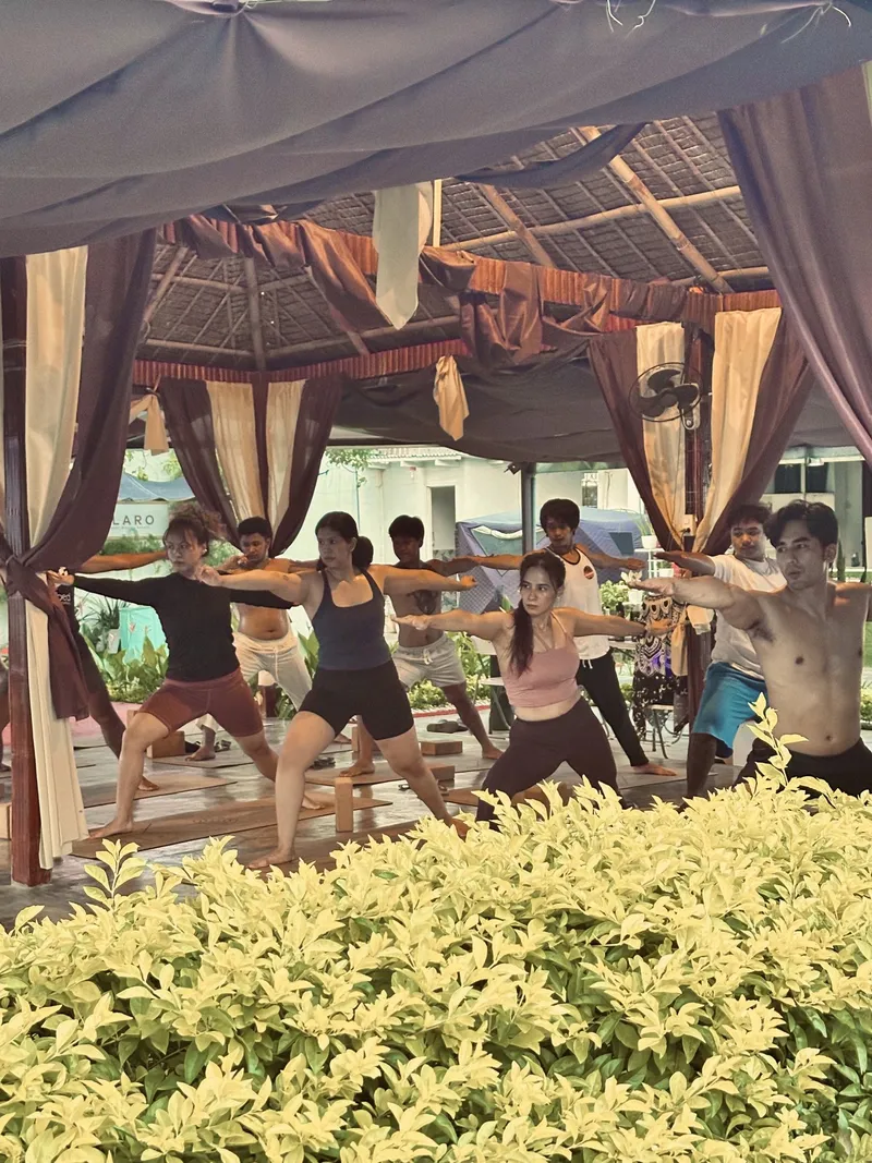 Students holding warrior pose outdoors